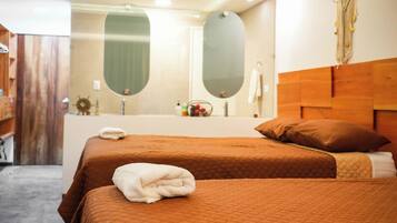 Une chambre d’hôtel avec deux lits, un grand miroir et une tête de lit en bois.