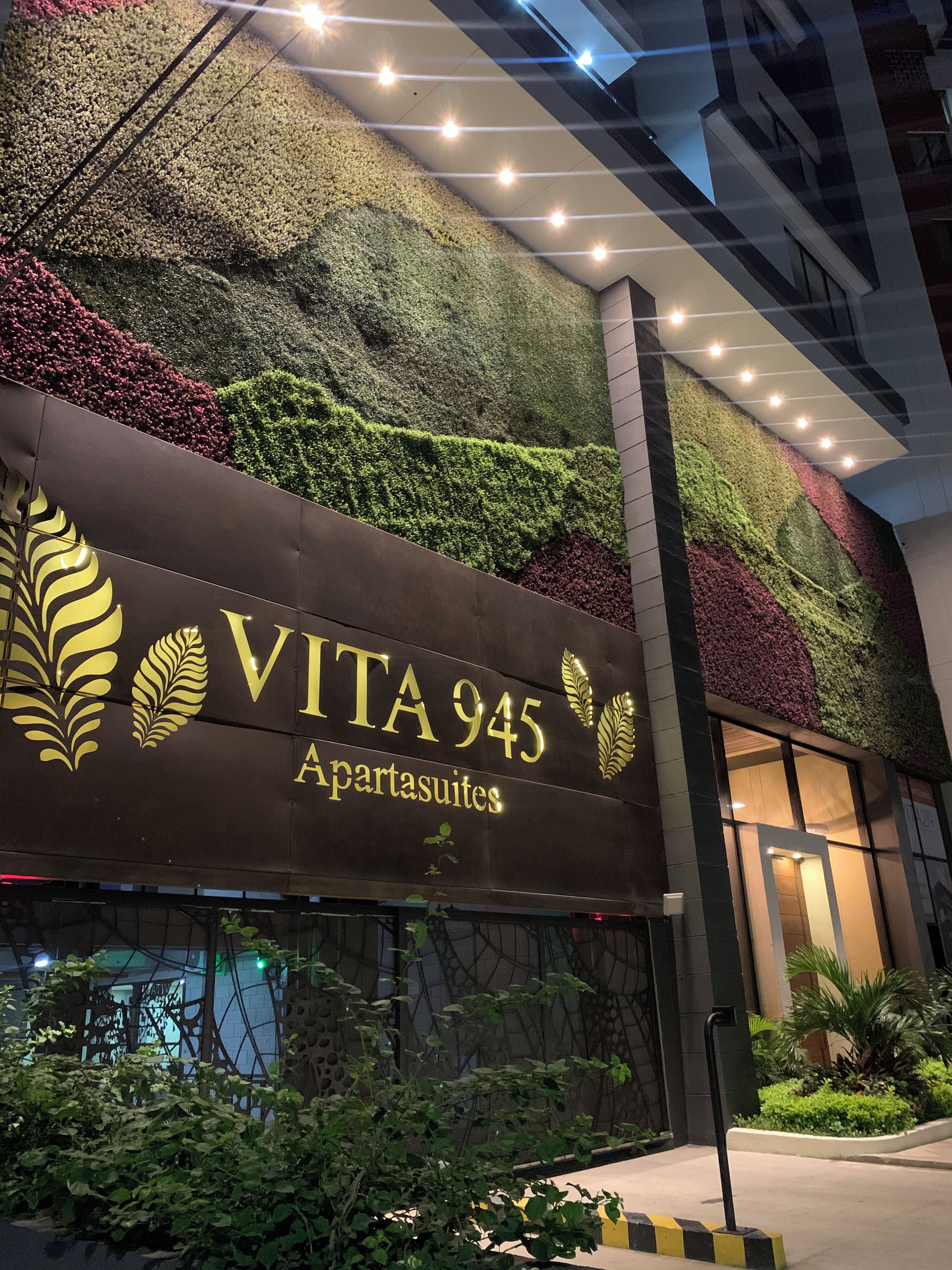 Un immeuble sur lequel on peut lire l’inscription « VITA 945 Apartasuites », et dont le mur est recouvert de plantes vertes.