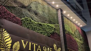 Un immeuble sur lequel on peut lire l’inscription « VITA 945 Apartasuites », et dont le mur est recouvert de plantes vertes.