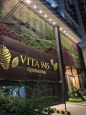 Un immeuble sur lequel on peut lire l’inscription « VITA 945 Apartasuites », et dont le mur est recouvert de plantes vertes.
