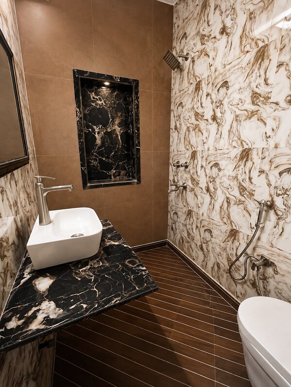 A bathroom with a marble vanity, a shower, and a toilet. - Hotel Swisston Palace (New Delhi)