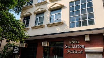 La façade d’un hôtel, sur laquelle on peut lire l’inscription « Swiston Palace Hotel ».