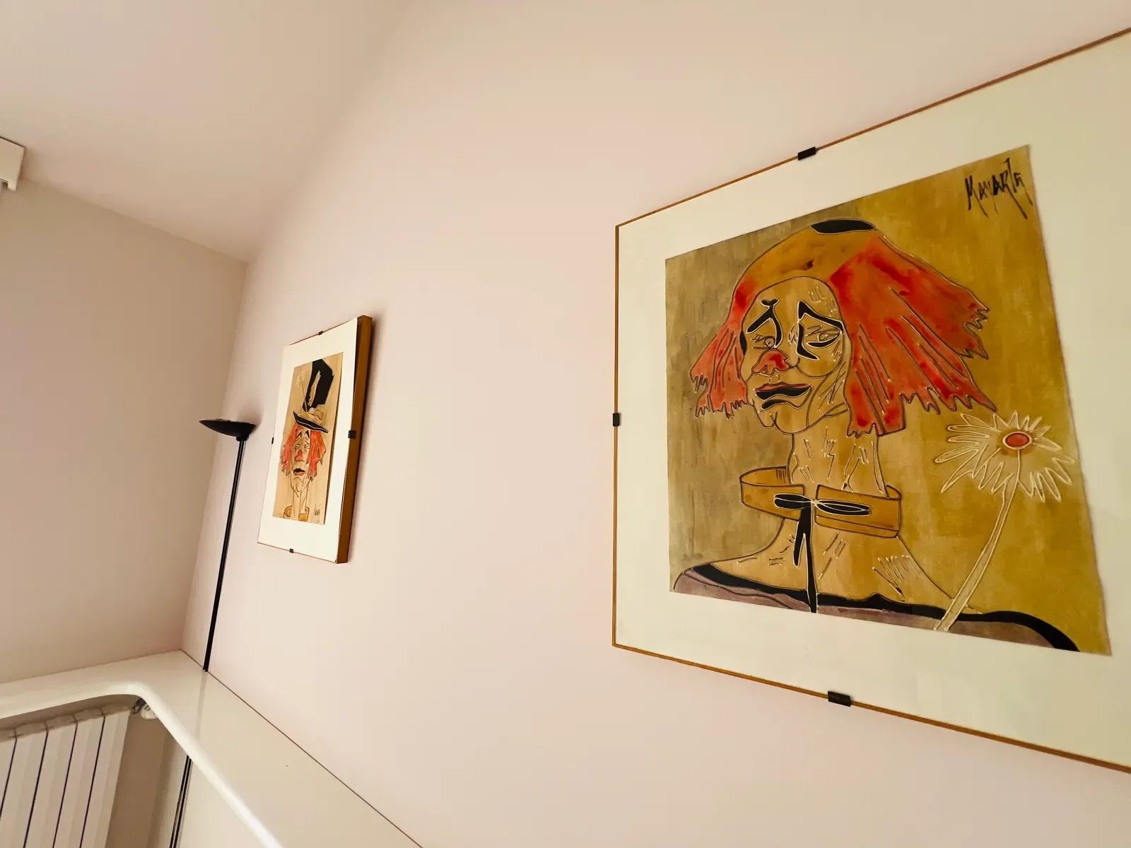 En hall med två inramade konstverk på väggen.