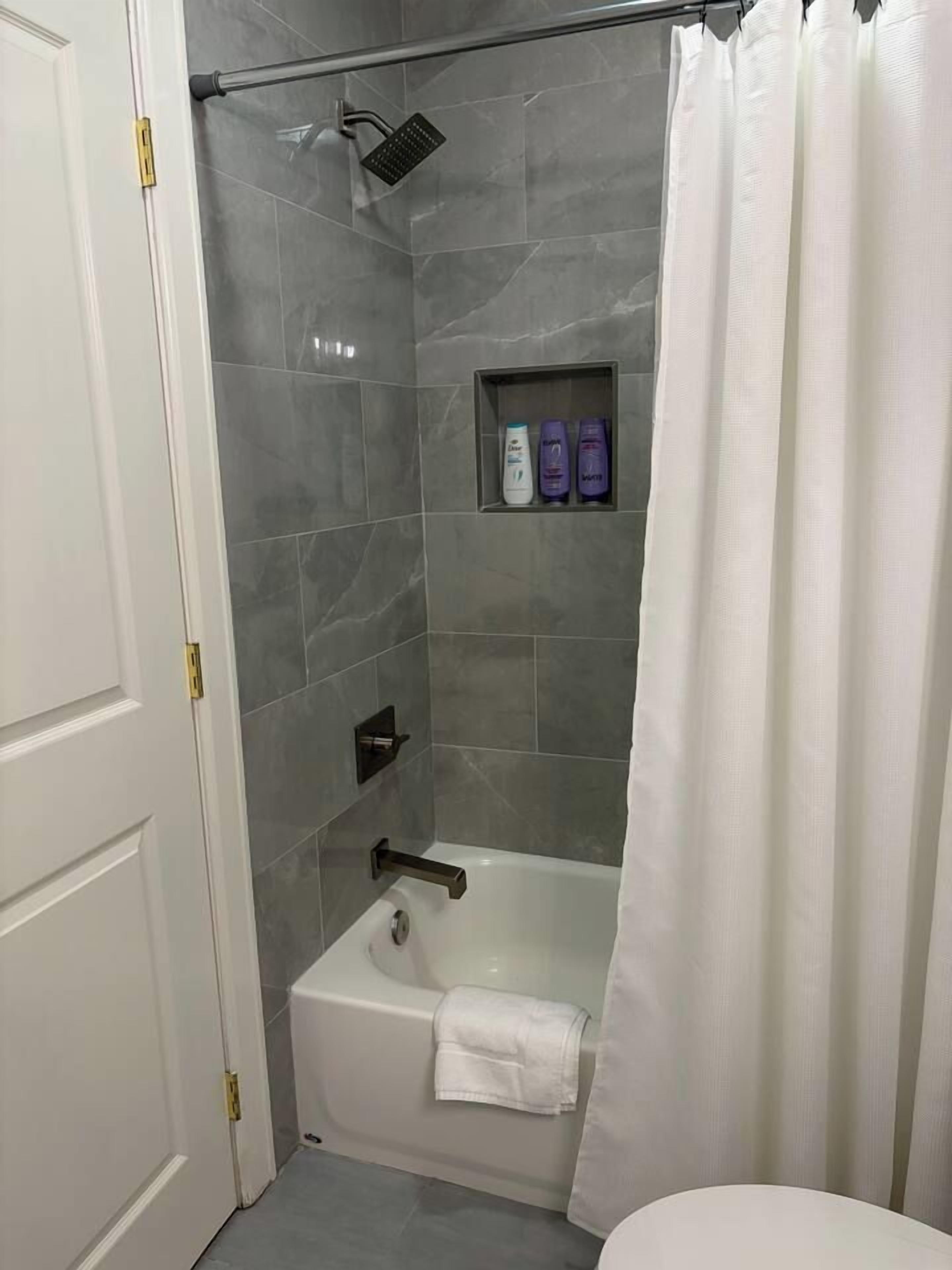 A bathroom with a shower, a bathtub, and a toilet.