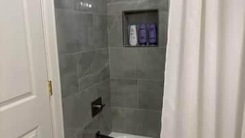 A bathroom with a shower, a bathtub, and a toilet.