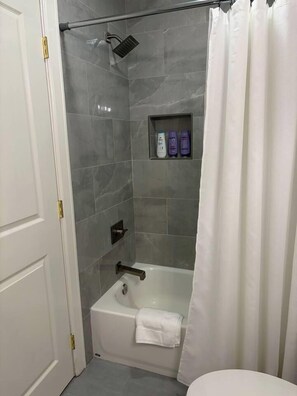 A bathroom with a shower, a bathtub, and a toilet. - Remodeled 3BR-2Bath House with Deck & Carport (Morrilton)