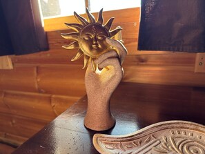 Una mesa de madera con una escultura decorativa de sol y un plato de madera tallada.