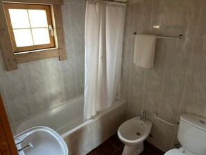 Un baño con bañera, un bidé y un inodoro.