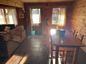 Un interior de madera con un sofá, una mesa y sillas.