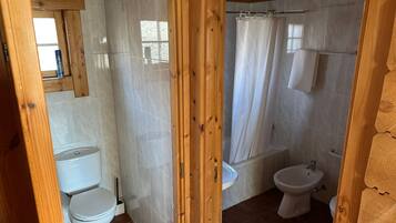 Ein Badezimmer mit Holzeinrahmung, Toilette, Bidet und Duschbereich.