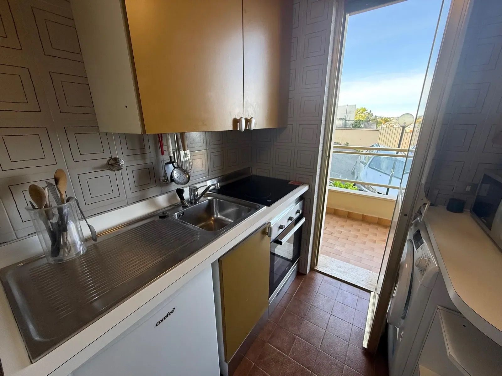 A compact kitchen with a dishwasher, a sink, and a stove.