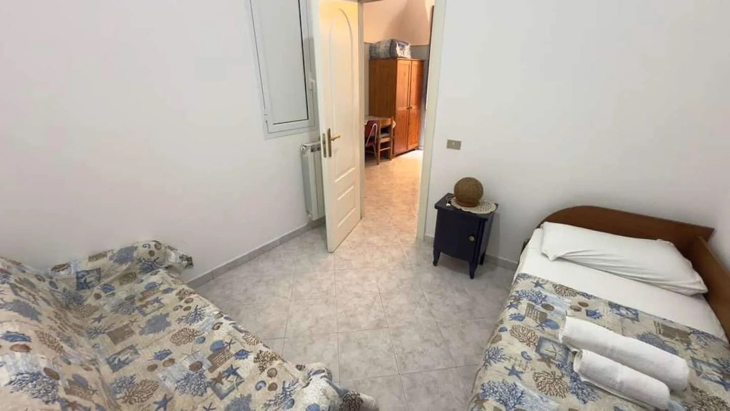 Ein Schlafzimmer mit zwei Betten, einem Nachttisch und einer Tür zu einem Badezimmer.