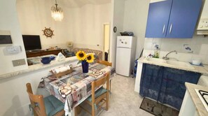 Eine kleine Küche mit Essbereich, Kühlschrank und Spüle.
