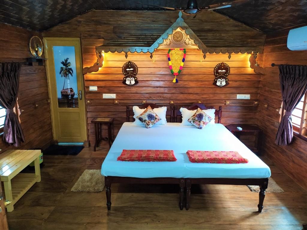 A wooden room with a bed, pillows, a bench, and a decorative wall.