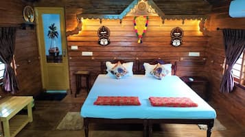 A wooden room with a bed, pillows, a bench, and a decorative wall.