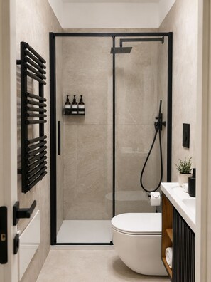 A modern bathroom with a glass-enclosed shower, a toilet, a sink with a mirror, and a towel rack. - AE Nova Studio – Panoramic Views of Caserta (Caserta)