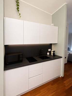 A compact kitchen with a microwave, sink, and cabinets. - AE Nova Studio – Panoramic Views of Caserta (Caserta)