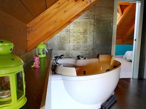 A bathroom with a bathtub, a green lantern, and a pink toy.