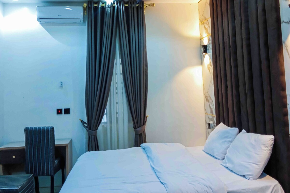 Una habitación de hotel moderna con una cama, un escritorio y una silla.