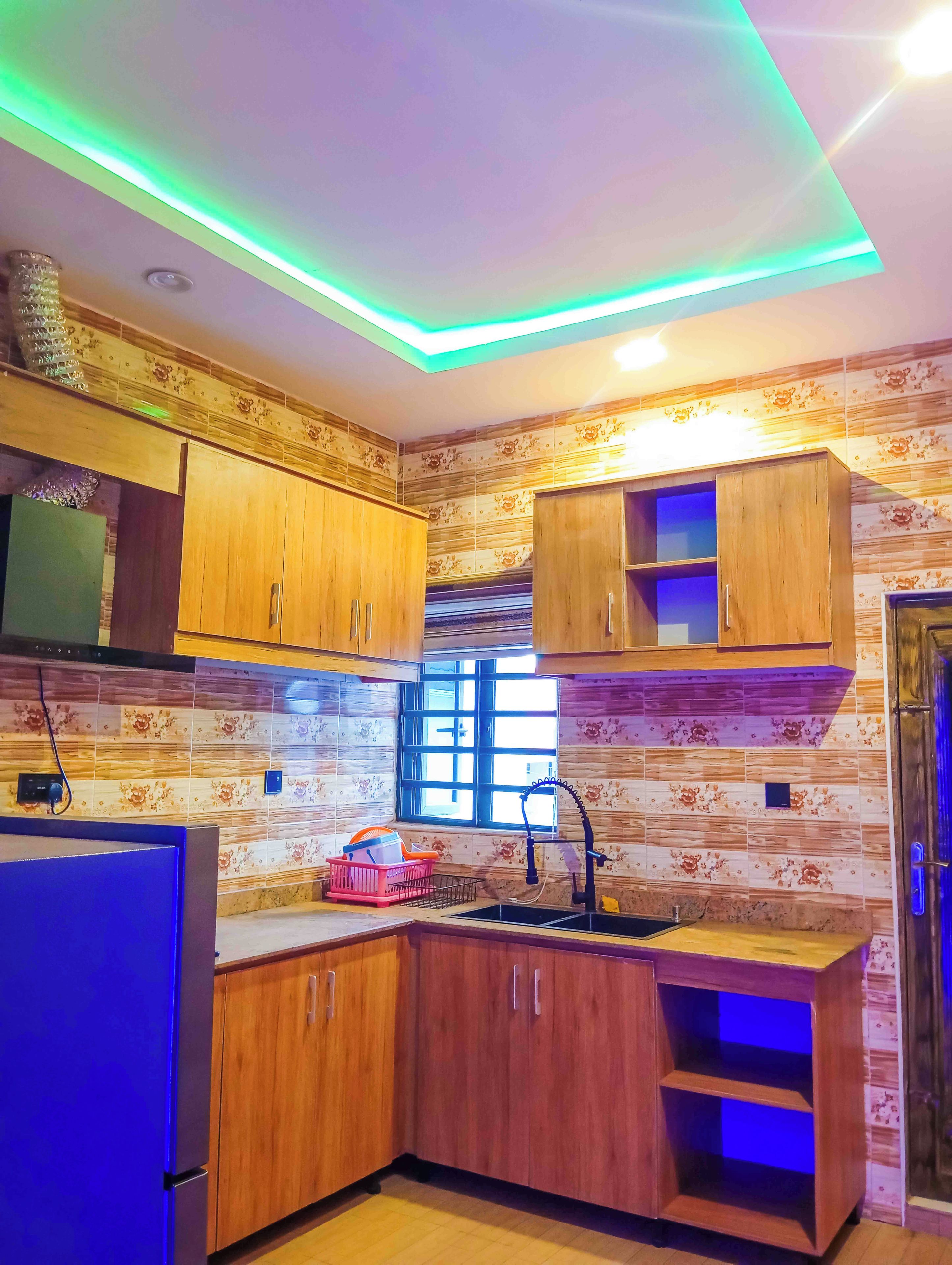 Una cocina con armarios de madera, una ventana y un lavamanos.