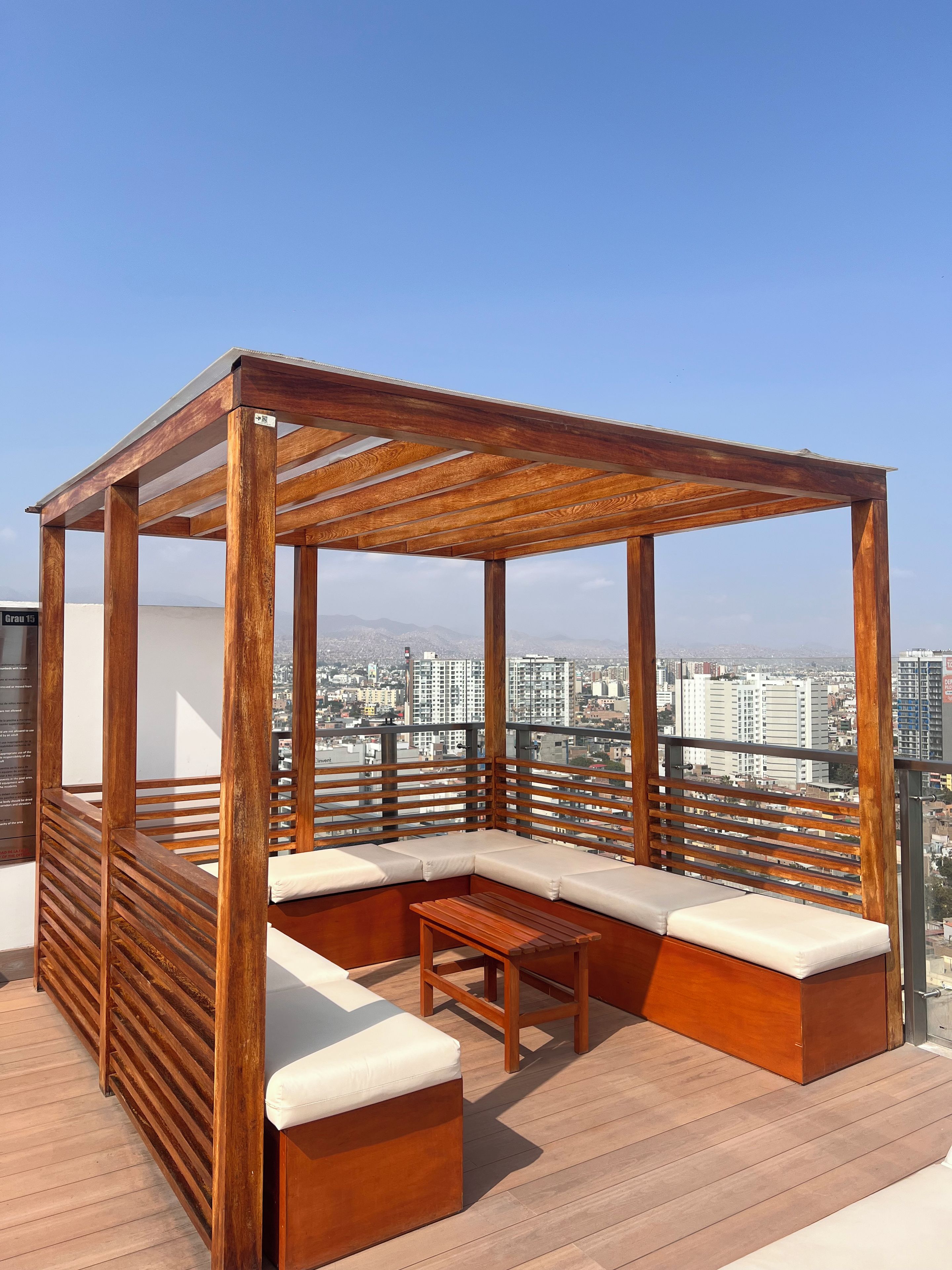 A wooden outdoor seating area with a view of the cityscape.