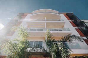 A multi-story building with balconies and large windows. - Pilar 1-Bedroom Apartment with Rooftop Pool (Asuncion)