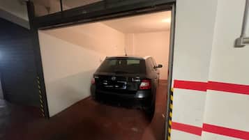 En parkeringskælder med en sort bil parkeret indeni.