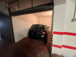 En parkeringskælder med en sort bil parkeret indeni.