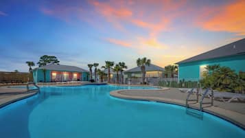A swimming pool with lounge chairs and a building with a blue exterior.