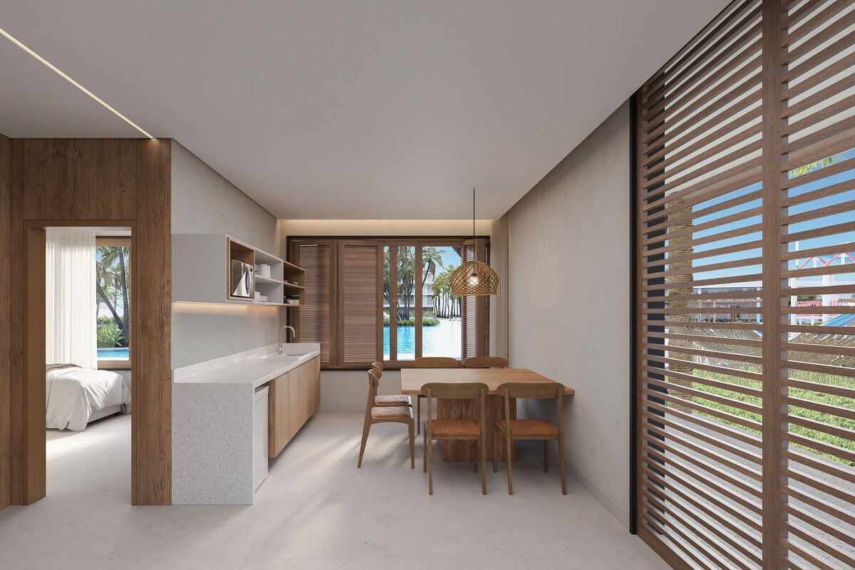 A modern kitchen with a wooden countertop, a dining area with a table and chairs, and a view of a swimming pool through large windows.