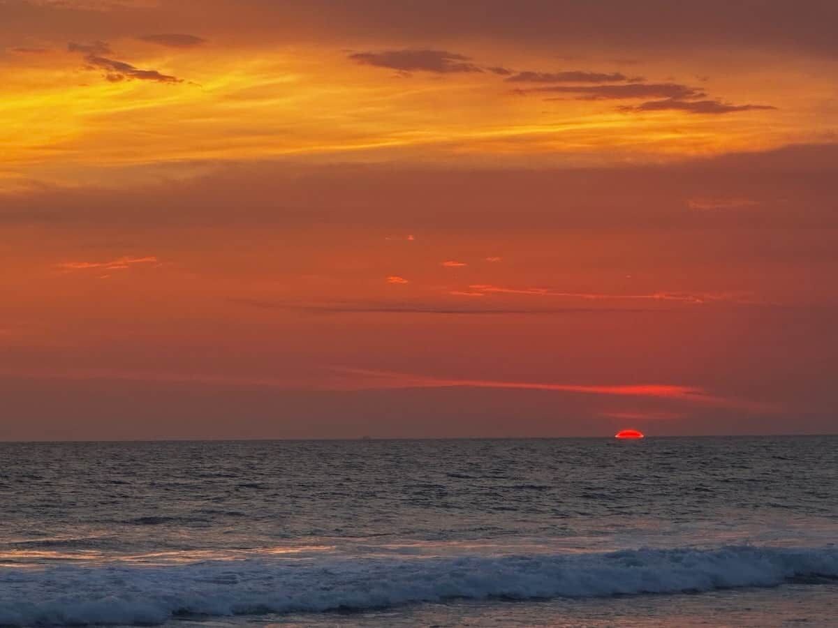Ein Sonnenuntergang über dem Meer mit ruhiger See und klarem Horizont.