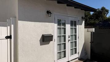 Un edificio con facciata bianca, tetto nero e ingresso chiuso da cancello.