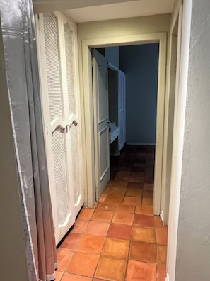 A narrow hallway with a tiled floor leading to a room with a door. - RESIDENCIAL LAUNDRY CNET (Las Terrenas)