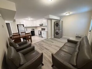 A modern apartment with a kitchen, dining area, and a living room with leather sofas. - Brand new guest suite in Burnaby (Burnaby)