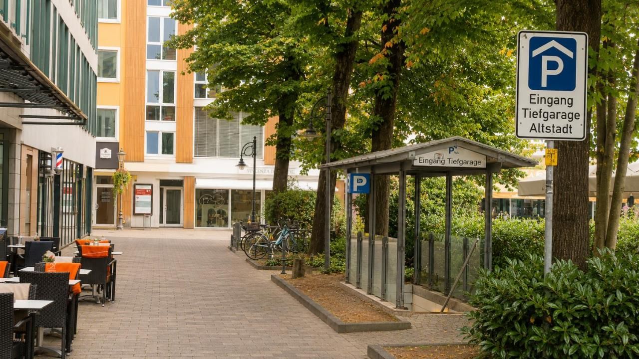 Un área de estacionamiento techada con un letrero que indica 'Eingang Tiefgarage Altstadt'.