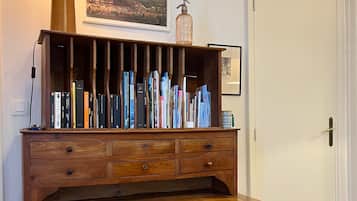 Ein Holztisch mit einer Lampe, einem Stuhl und einer Bücherwand voller Bücher.