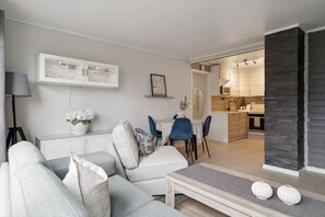 A modern living room with a sofa, chairs, a coffee table, and a dining area. - Winter Garden Apartment | Tromsø City (Tromsø)
