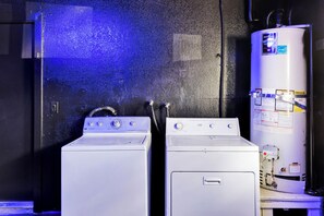 Ein Waschraum mit zwei Waschmaschinen und einem Warmwasserbereiter.