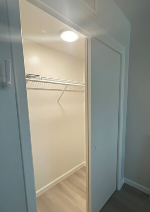 A walk-in closet with a ceiling light, a metal rack, and a door. - Modern 2-bedroom condo close to Hospitals and Shops-centrally located Rio Rancho (Rio Rancho)