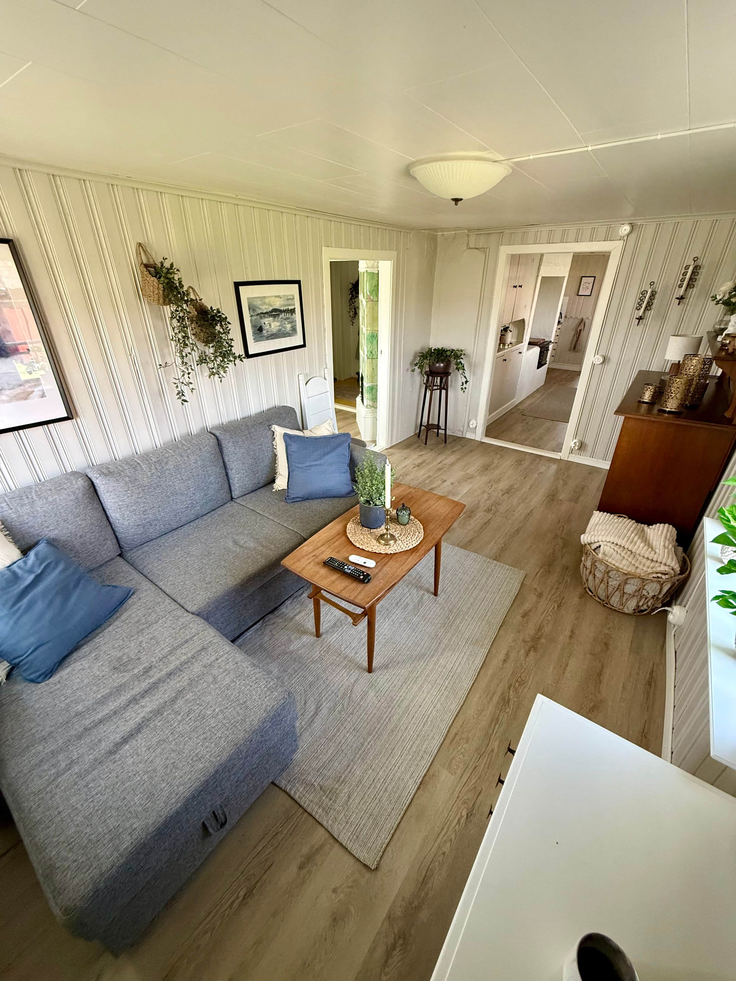 Un salon moderne avec un canapé d’angle, une table basse et une vue sur la salle à manger.