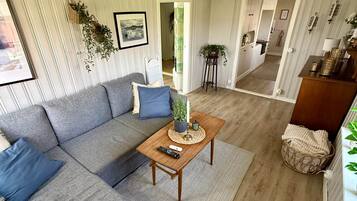 Un salon moderne avec un canapé d’angle, une table basse et une vue sur la salle à manger.