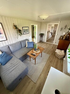 Una sala moderna con un sofá modular, una mesa de centro y vistas al comedor.