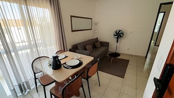 Un comedor con una mesa, sillas y un ventilador.