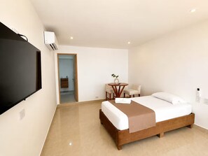 Een hotelkamer met een bed, een bureau, een stoel en een televisie.