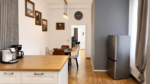 Een moderne keuken met een houten aanrecht, een koelkast en een eethoek met stoelen en een tafel.