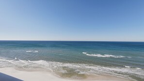 Une plage avec une eau d’un bleu limpide et un rivage sablonneux.
