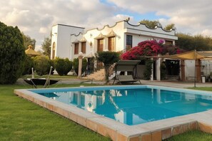 A swimming pool with a white building in the background.