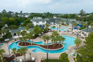 Ein Resort mit mehreren Schwimmbecken, Palmen und Liegebereichen.
