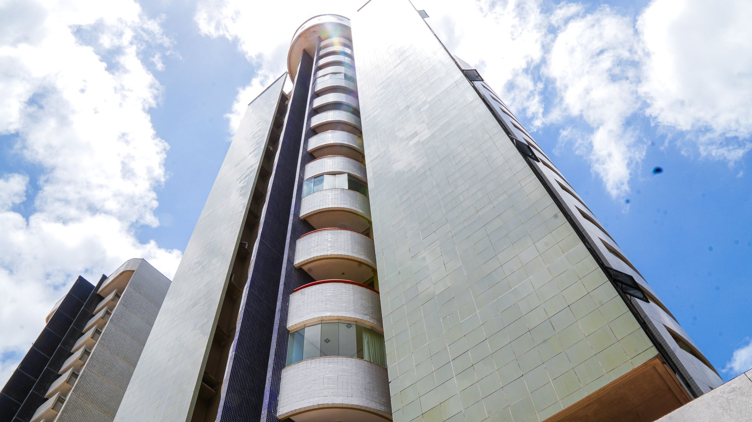 Um edifício alto com várias varandas e céu limpo.