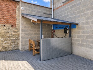 Un pequeño espacio al aire libre con techo metálico y una mesa.